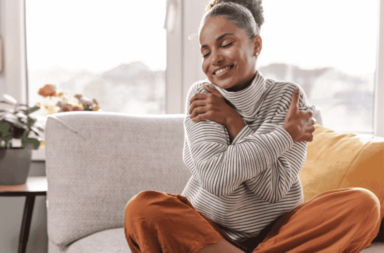 Woman hugging herself as a form of self-care to support her wellness